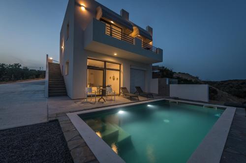 a villa with a swimming pool in front of a house at Villa Oneiro Kefalos in Kefalos
