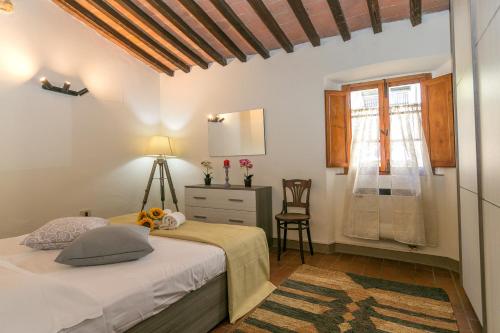 ein Schlafzimmer mit einem Bett, einer Kommode und einem Fenster in der Unterkunft La Casina di Gigliola in Bibbona