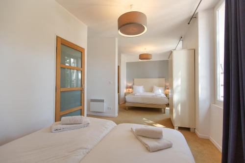 a white room with two beds and a bedroom at Hôtel de la Plage - Ronce-les-bains in Ronce-les-Bains