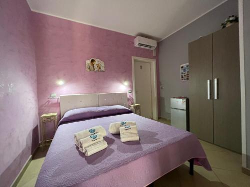 a pink bedroom with a bed with towels on it at B&B Le Onde Del Mare in Gallipoli