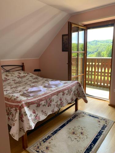 a bedroom with a bed and a large window at Hostel Strug in Makole