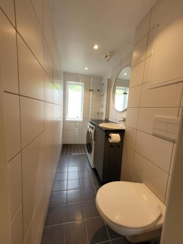 a small bathroom with a toilet and a sink at Telemark Apartments Langgt 48 in Porsgrunn