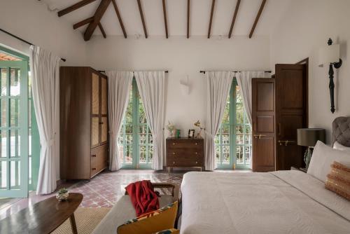 Marna的住宿－VianaarEscapes-Cardo-IndoPortuguese Villa-Assagao，一间卧室设有一张床和两个大窗户
