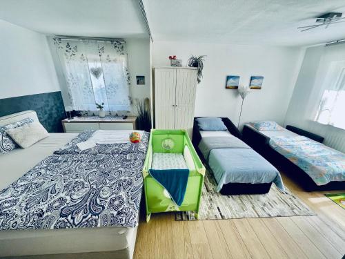 a room with two beds and a crib in it at Apartment Messe Karlsruhe in Rheinstetten