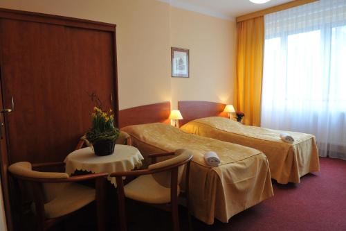 a hotel room with two beds and a table at Nadmorski in Mrzeżyno