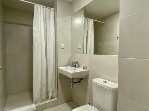 a bathroom with a toilet and a sink and a shower at Figaro Suites in Prague