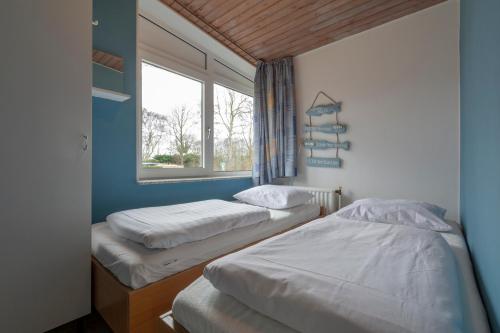Duas camas num quarto com uma janela em Duinland 90 Sint Maartenszee em Sint Maartenszee