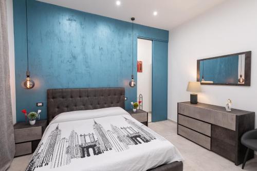 - une chambre avec un lit et un mur bleu dans l'établissement LA DIMORA E IL REDENTORE, à Bari
