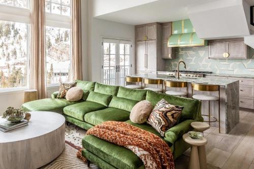 a living room with a green couch and a kitchen at Palace de Pow in Alta