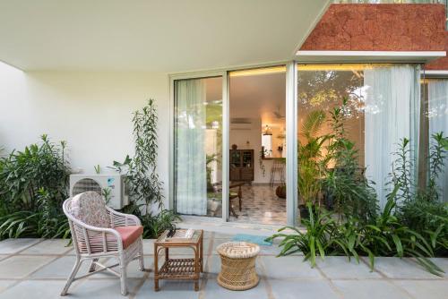 a patio with two chairs and a table at El Sereno 2 BHK Stylish Apartments In Vagator with Garden and Pool- 10 minutes drive to Vagator Beach in Chapora