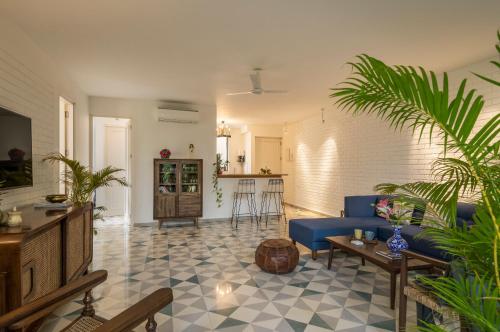 a living room with a blue couch and a table at El Sereno 2 BHK Stylish Apartments In Vagator with Garden and Pool- 10 minutes drive to Vagator Beach in Chapora