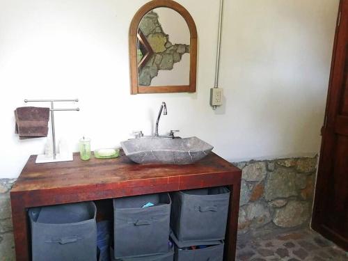 a bathroom with a stone sink on a wooden counter at Casa Montagnola: naturaleza y tranquilidad in Teotitlán del Valle