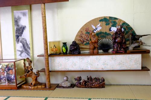 a shelf filled with figurines on a wall at Asumi Onsen in Fujiyoshida