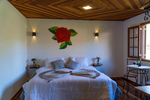 a bedroom with a bed with a flower on the wall at Montanhas Do Visconde in Visconde De Maua