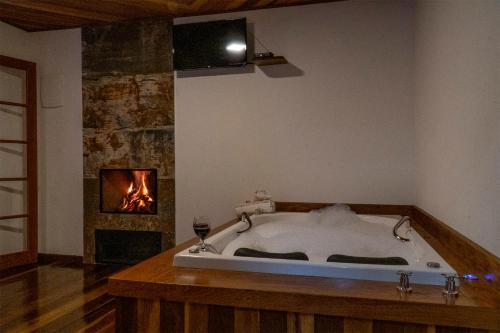 a bath tub in a room with a fireplace at Montanhas Do Visconde in Visconde De Maua