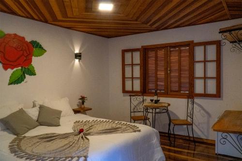 a bedroom with a bed with a flower on the wall at Montanhas Do Visconde in Visconde De Maua