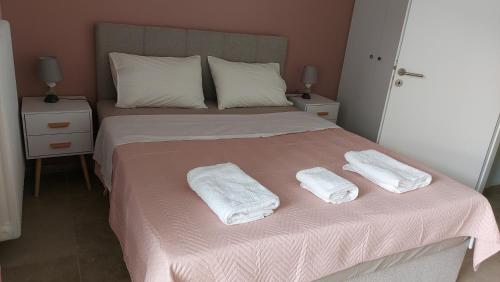 a bedroom with a bed with two towels on it at Hermes green in Artemida