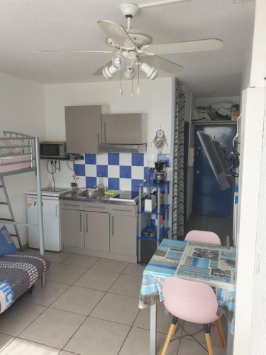 - une petite cuisine avec une table et un lit dans l'établissement Location Studio Saint-Cyprien avec parking, à Saint-Cyprien