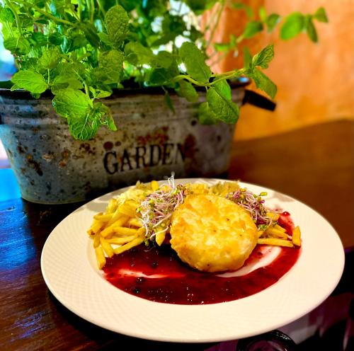 a plate of food on a table with a plant at Troll in Cisna