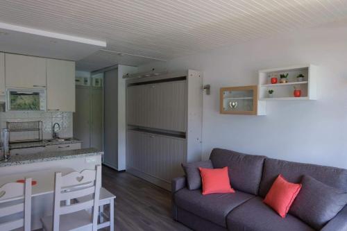 a living room with a couch and a kitchen at Tignes Joli Studio avec vue imprenable sur le lac in Tignes