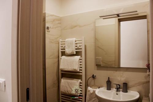 bagno con lavandino, specchio e asciugamani di Casa degli Amici a Ruvo di Puglia