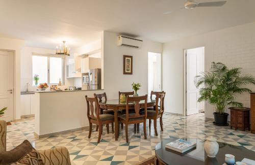 a dining room and kitchen with a table and chairs at El Sereno 2 BHK Stylish Apartments In Vagator with Garden and Pool- 10 minutes drive to Vagator Beach in Chapora