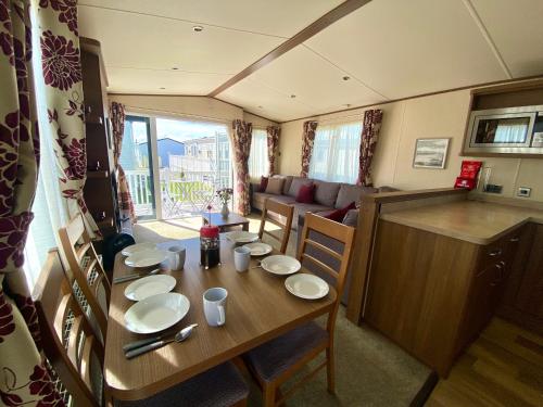 a dining room with a table and a living room at Winchelsea Beach Holiday Home - Pool & Beach in Winchelsea