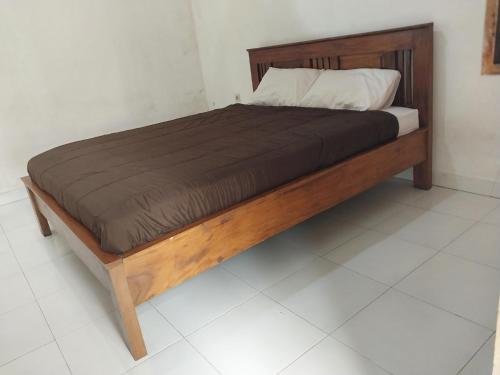 a bed in a bedroom with a wooden bed frame at Lombok Collection Gili Air in Gili Islands