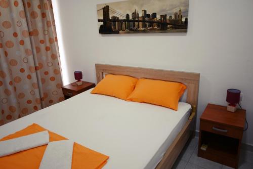 a bedroom with a bed with orange pillows at Top Jaz Apartments in Budva