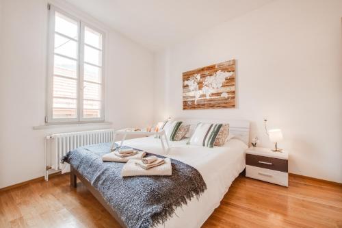 a white bedroom with a bed and a window at Esclusivo appartamento storico a ☆☆☆☆☆ - BELLINZONA in Bellinzona