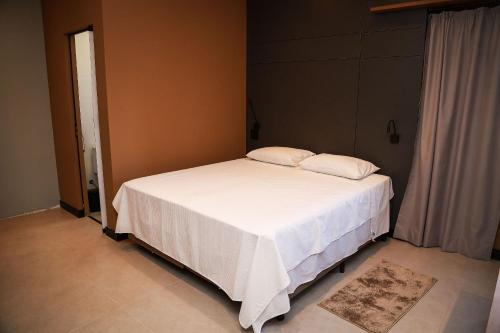 a bedroom with a bed with two pillows on it at Globo Lar Studios in Limeira