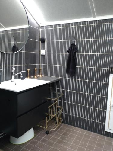 Muuruvesi的住宿－SkillHill，黑色浴室设有水槽和镜子