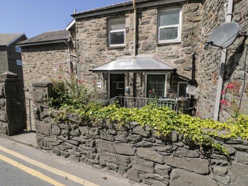 a stone house with a stone wall and a window at 4A Victoria Place in Barmouth