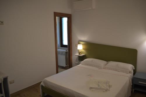 a bedroom with a bed with a green headboard at Dimora Cice in SantʼAgata deʼ Goti