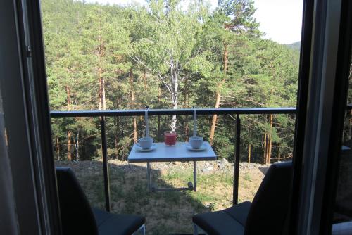 einen Tisch auf einem Balkon mit Waldblick in der Unterkunft Planinac 03 in Divčibare