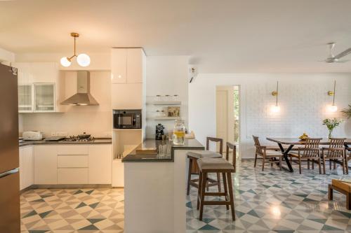 a kitchen and dining room with a table and chairs at El Sereno 2 BHK Stylish Apartments In Vagator with Garden and Pool- 10 minutes drive to Vagator Beach in Chapora