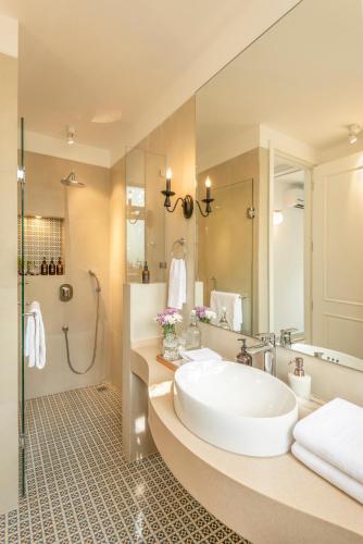 a bathroom with a large white tub and a shower at El Sereno 2 BHK Stylish Apartments In Vagator with Garden and Pool- 10 minutes drive to Vagator Beach in Chapora