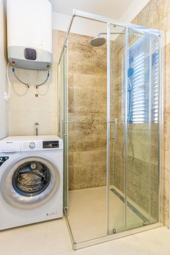 a washing machine in a bathroom with a shower at ISLAND GETAWAY in Cres