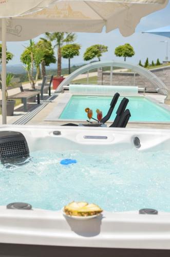 a hot tub in a swimming pool with chairs at Three Stars Luxury House ART-PE with pool and SPA pool in Trebnje