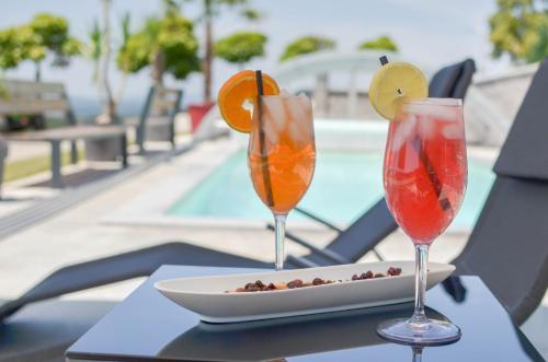 two cocktails on a table with a plate of food at Three Stars Luxury House ART-PE with pool and SPA pool in Trebnje