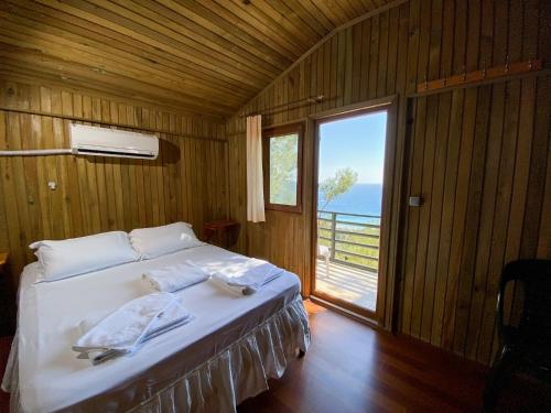 a bedroom with a bed with a view of the ocean at Tree Houses Hotel in Fethiye