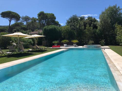 a swimming pool in a yard with chairs and umbrellas at Arli Hotel Hideaway Punta Ala - Adults Only in Punta Ala