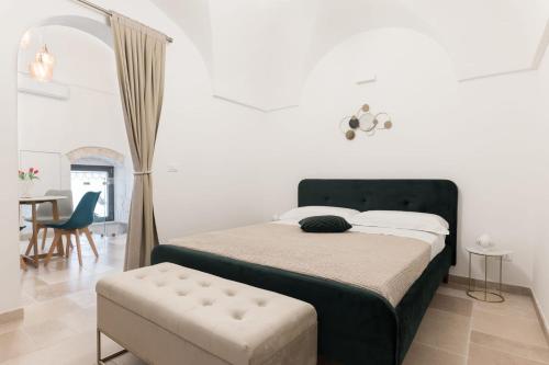 una camera con letto, sedia e tavolo di Alba Luxury Suite a Ostuni