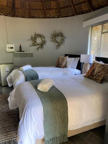 a bedroom with two beds with white sheets at Pretoria Country Club - Old Tree Hut in Pretoria