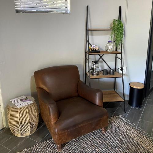 a brown leather chair in a room with a shelf at Pretoria Country Club - Old Tree Hut in Pretoria