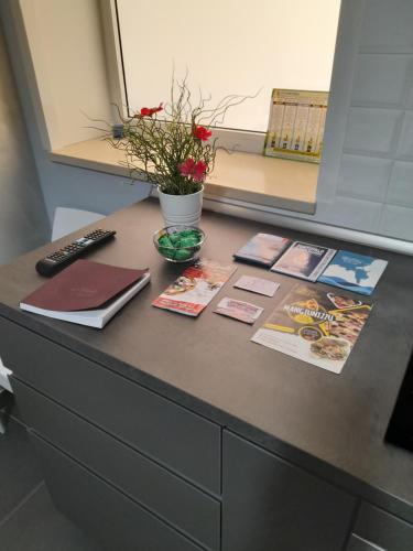 a desk with books and magazines on top of it at Maison Ane Marie in Avola