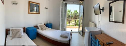 a small room with two beds and a balcony at Philoxeni Akti in Kanali