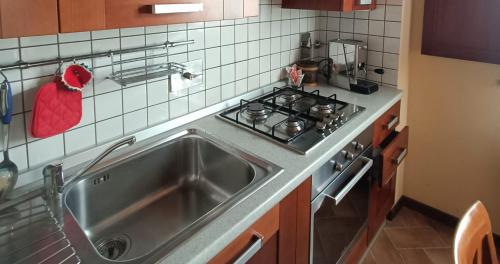 a kitchen with a stainless steel sink and a stove at Appartamento con piscina Il Borghetto - vicino San Gimignano in Gambassi Terme