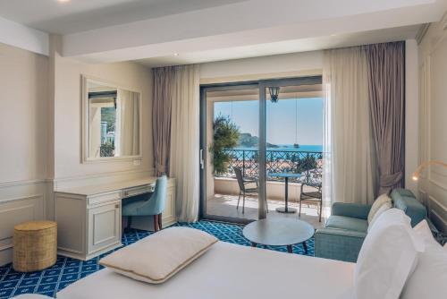 a hotel room with a bed and a balcony at Iberostar Waves Slavija in Budva