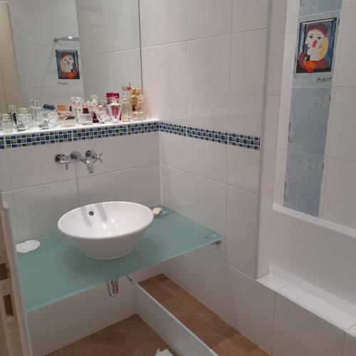 a white bathroom with a sink and a shower at chez MARINO antony real in Orange